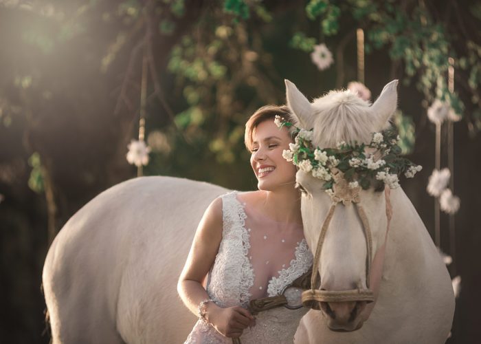 Novia romantica junto a caballo blanco